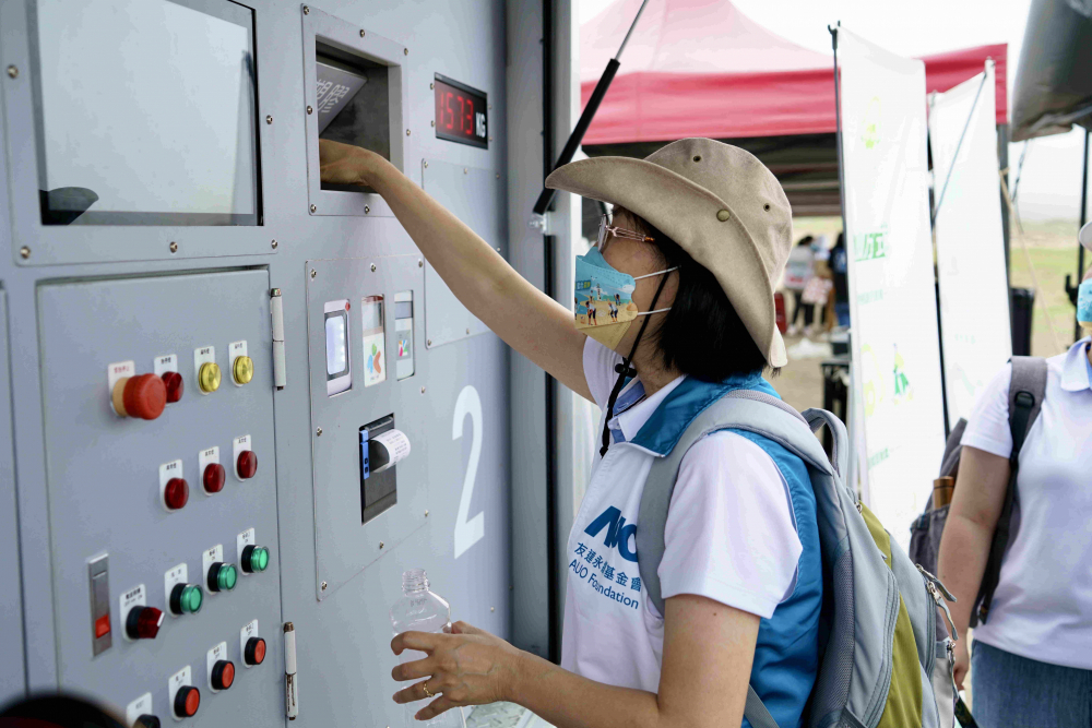 志工們將拾起的寶特瓶投入「好歸塑專車」，讓廢棄塑料空瓶可以直接粉碎、縮小體積，未來將可再製成購物袋、寶特衣、悠遊卡等生活用品